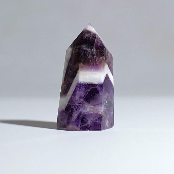 A beautiful Amethyst crystal point, standing for display. Affordable crystal, front facing to camera
