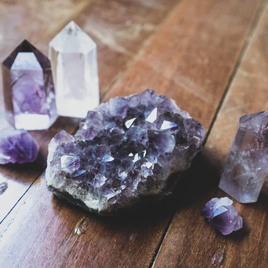 A collection of crystals. There is a clear quartz point, an amethyst tower, an amethyst crystal clusters. All of these are great crystals for a beginner crystal collector!